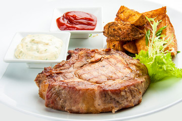 Steak from pork chop with potatoes on a white plate