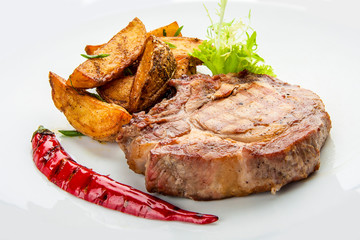Steak from pork chop with potatoes on a white plate