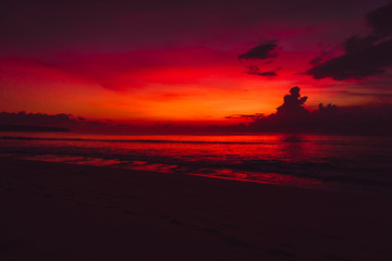 Colorful red bright sunset or sunrise at beach with ocean