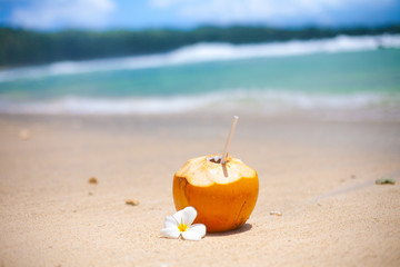 Tropical cocktail in a coconut on a beautiful beach on Mahe island
