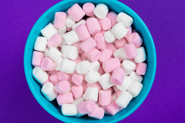 marshmallow laid out on violet paper background.
