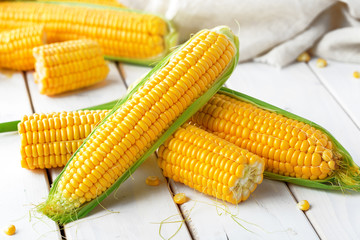 Raw corn on a wooden table