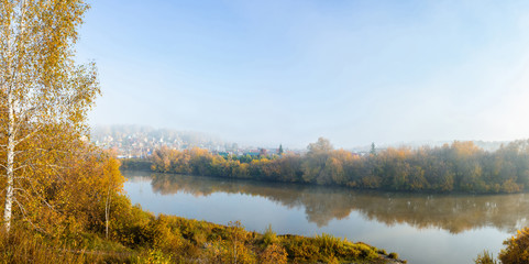 Beautiful panorama of morning on the calm river with village on their bank 