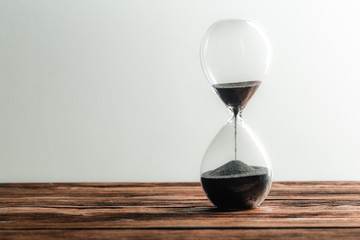 Modern hourglass on wooden background