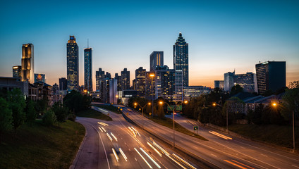 Obraz na płótnie Canvas Evening car traffic flowing against city skyline
