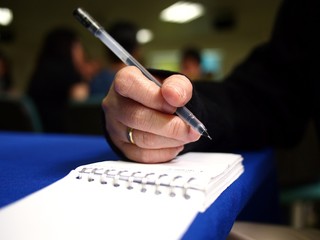Hand writing on a notebook using a pen