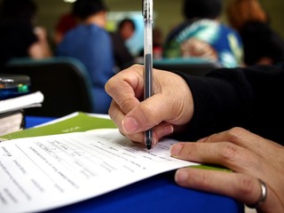 Hand writing on a notebook using a pen