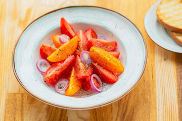 Traditional Italian salad with fresh tomatoes, onions and olive oil