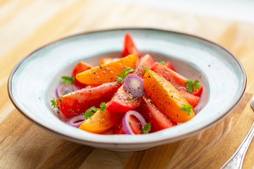 Traditional Italian salad with fresh tomatoes, onions and olive oil