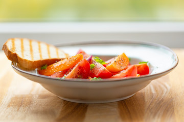 Traditional Italian salad with fresh tomatoes, onions and olive oil