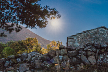Stone fence with the moon in the background at night
