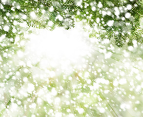 Fototapeta na wymiar Christmas background with white snow, green Xmas tree twig and abstract bokeh light
