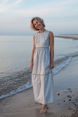 
Natural portrait of a beautiful blond woman in a dress near the sea
