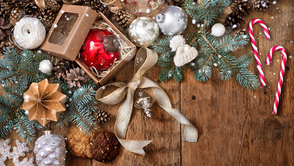 Christmas decorations on fir-tree branches and gifts on wooden background