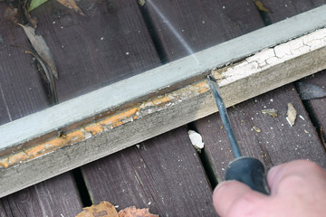 Removing glazing putty from old window. Home renovation concept, close up image with copy space.