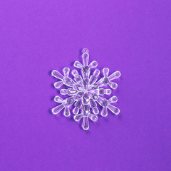 Creative Christmas snowflake decoration with purple background. Minimal flat lay concept.