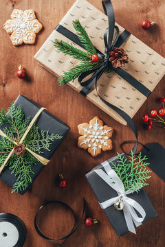 flat lay with presents, christmas balls, fir branches and cookies on wooden background