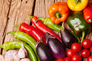 Cherry tomatoes, peppers, garlic, eggplants on a wooden table. Fresh organic vegetables..