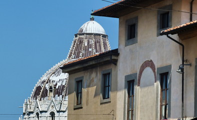 The Baptistery behind the buildings of Pisa, Tuscany, Italy