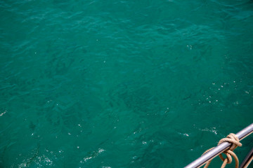 Green blue sea water surface and yacht tackle top view photo. Still sea surface with wind ripples. Idyllic cruise banner