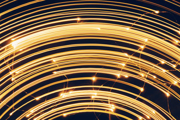Blurred bright luminous golden stripes in the form of an arc from diode bulbs LED from Christmas lights screen closeup. Bright abstract background ideal for any design