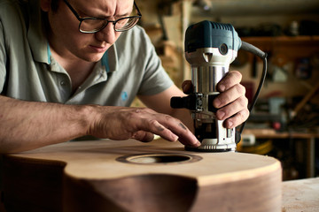 Luthier Install Binding on an guitar. Chamfering on the body of the guitar.