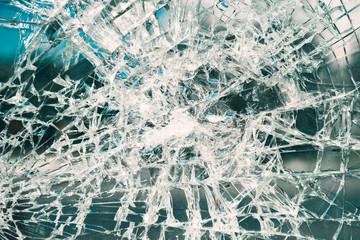 Criminal incident at the bus stop. Shooting a pistol. Hole and cracks in the glass of a city bus stop. Cracked glass texture against the blue sky. Cracked glass with a hole from a bullet. Vandalism