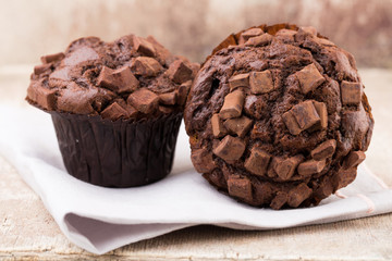 Homemade muffins with chocolate, vintage background.