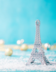 Fototapeta na wymiar Christmas, New Year blue background with snow and Eiffel tower ornament. Copy space.