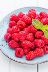 Fresh raspberries in a plate on a  vintage background.