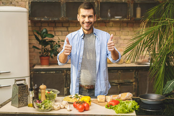 Portrait of young man preparing delicious and healthy food in the home kitchen on a sunny day....