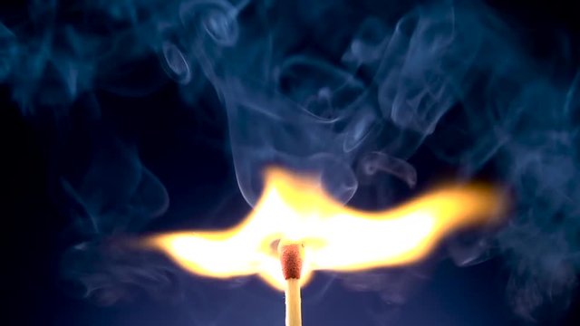 Burning match on a black background in slow motion