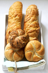 Kaiser wheat and rye flour buns with seeds, mini baguettes with ham and cheese, fresh bread.