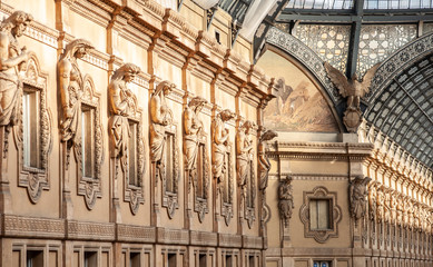 Obraz premium The statues of Galleria Vittorio Emanuele II in Milan, Italy. Built in 1875 this gallery is one of the most popular landmarks and luxury shopping areas in the city