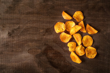 homemade organic potato chips on a wooden background, rustic style