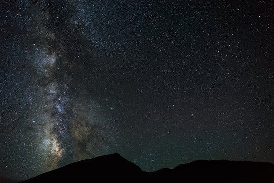 The bright stars of the Milky Way in the night sky over the mountains of the North Caucasus.