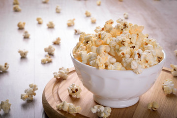 Salt popcorn on the wooden table, selective focus