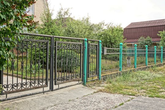 black iron gates and metal fence outside in green grass
