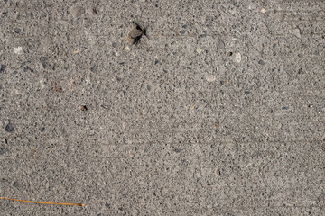 Grunge asphalt texture. Uneven concrete surface closeup. Weathered grungy surface photo background.