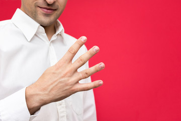 Attractive guy shows four finger up, number 4, front view, bright red background with copy space, for advertising, close up