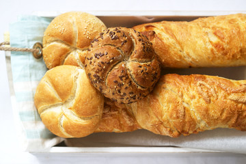 Kaiser wheat and rye flour buns with seeds, mini baguettes with ham and cheese, fresh bread.