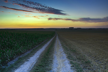 Colorful sky after sunset over a dirt road