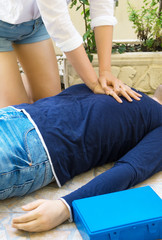 Woman doing cardiopulmonary resuscitation to a man.