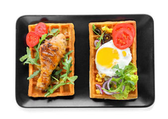 Delicious waffles with chicken drumstick and fried egg on plate, isolated on white