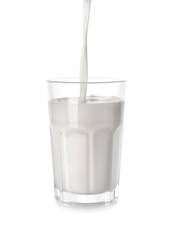 Pouring of tasty milk in glass on white background