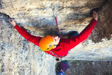 Climber in a helmet climbs up.