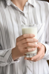 Woman holding glass of tasty milk, closeup