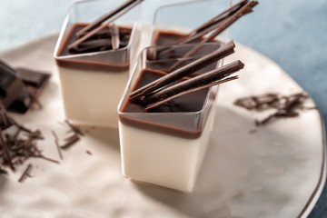 Glasses with tasty chocolate panna cotta on plate, closeup