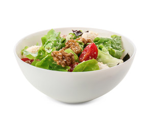 Delicious fresh salad with walnuts in bowl on white background