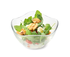 Delicious fresh salad with walnuts in glass bowl on white background